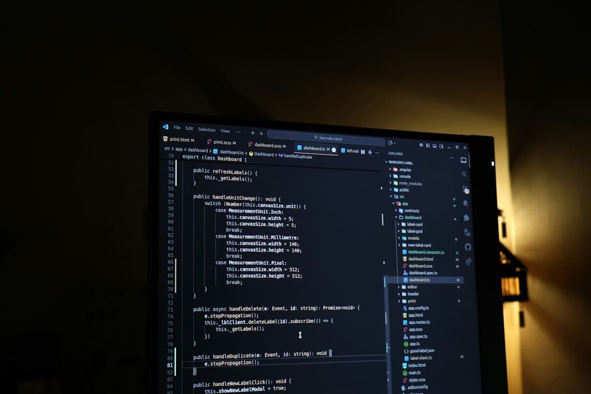 A monitor showing source code in a dark workspace